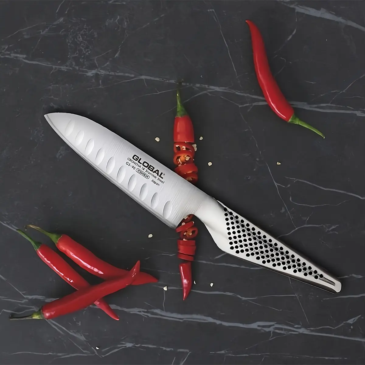 Nóż santoku Global z czerwonym chili – ostrze do precyzyjnego krojenia.